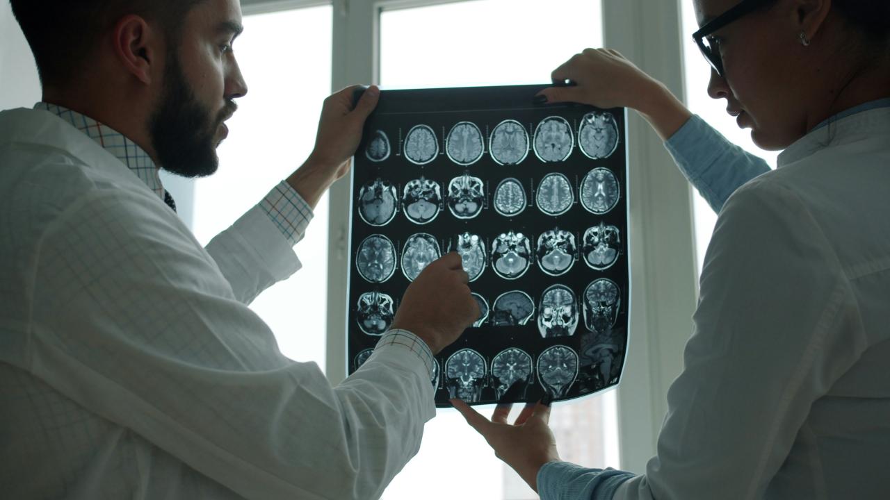 Two doctors examining a brain mri scan together.