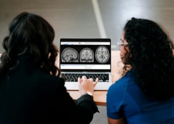 Two women looking at a computer screen with mri images on it